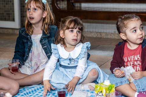 Foto de festa de aniversário infantil com crianças atentas à recreação durante a comemoração da Alice no Tatuapé.'