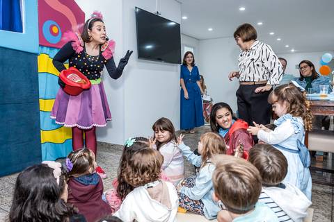 Fotógrafo de aniversário infantil registra as crianças interagindo com a recreadora durante a festa da Alice no Tatuapé.'