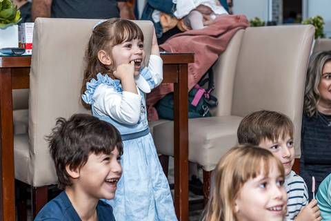 Foto de festa de aniversário infantil no Tatuapé, com a aniversariante Alice e seus amigos gargalhando durante a recreação.'