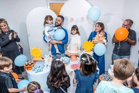 Fotógrafo de aniversário infantil registra a hora do parabéns na festa da Alice no Tatuapé, com a família e convidados celebrando.'