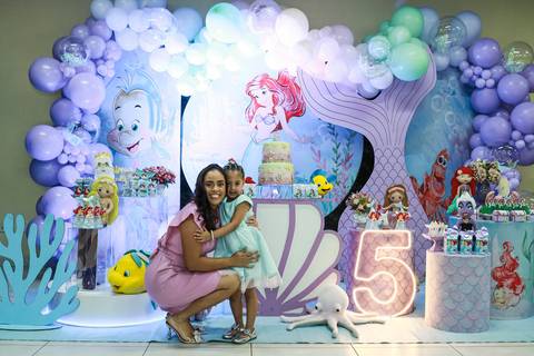 Fotografia de festa infantil na Vila Maria, registrando a aniversariante Melissa abraçada com sua mãe na festa com tema Pequena Sereia.'