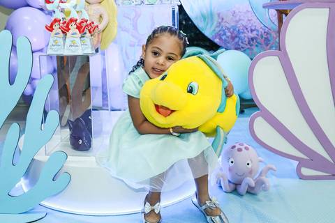Foto de festa infantil na Vila Maria da aniversariante Melissa abraçando um boneco do Linguado, em sua festa de 5 anos com tema Pequena Sereia.'
