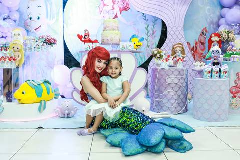 Fotógrafo de aniversário infantil na Vila Maria registra a aniversariante Melissa no colo da personagem Ariel, em sua festa com tema Pequena Sereia.'