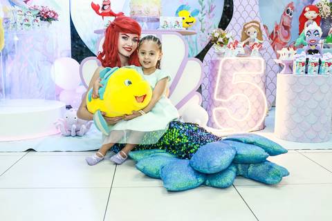 Foto de festa infantil na Vila Maria, com a aniversariante Melissa abraçando o Linguado ao lado da Pequena Sereia no Buffet Magia Kids Prime.'