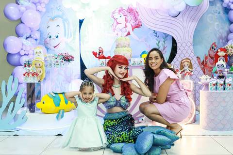 Fotografia de festa infantil na Vila Maria, mostrando a aniversariante Melissa, sua mãe e a personagem Ariel posando para a foto no Buffet Magia Kids Prime.'