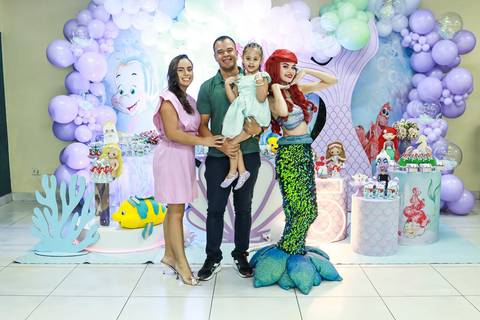 Fotografia de aniversário infantil no Buffet Magia Kids Prime, na Vila Maria, mostrando a família da Melissa com a Ariel em frente à decoração da festa.'