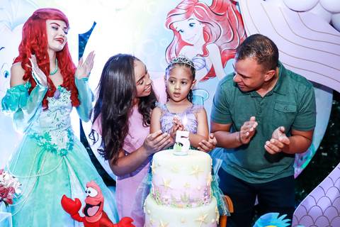 Fotógrafo de aniversário infantil na Vila Maria registra a família cantando parabéns para a Melissa em sua festa com tema Pequena Sereia.'