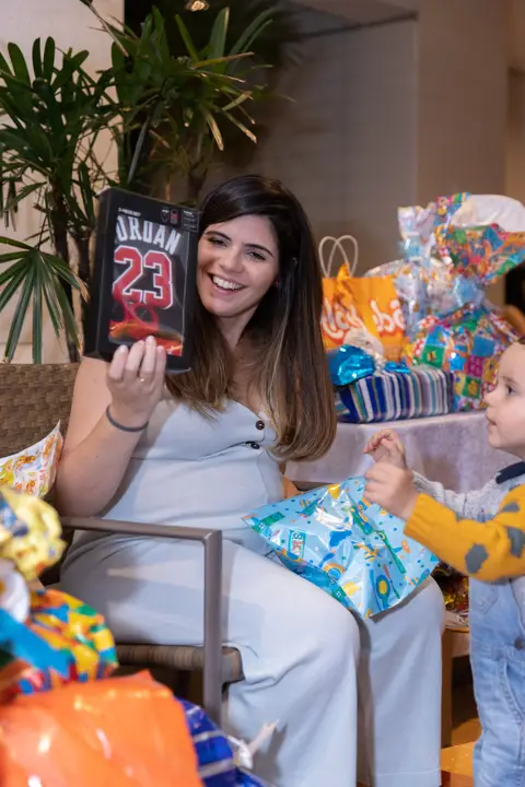 Chá de bebê. Mãe abrindo presentes'