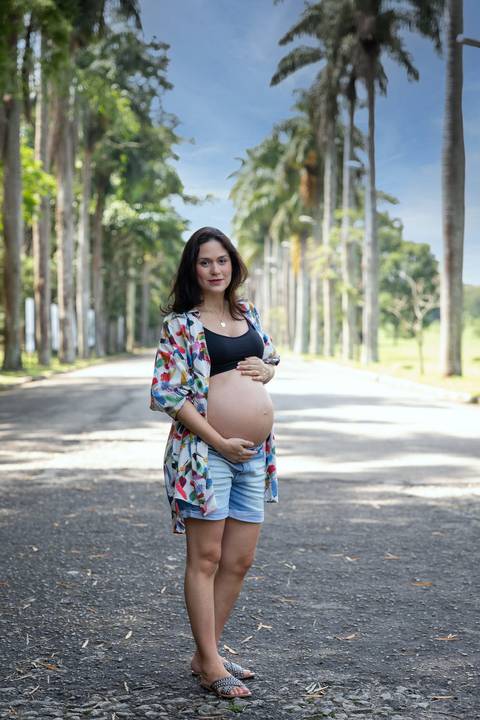Mãe gestante com palmeiras ao fundo no Jardim Botânico de São Paulo'
