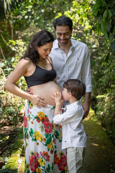 criança beijando barrida da mãe gestante no Jardim Botânico de São Paulo'