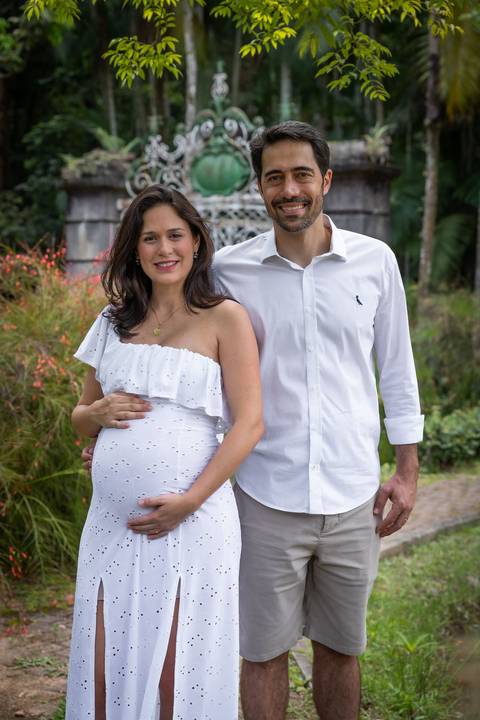 casal com gestante com portão ao fundo no Jardim Botânico de São Paulo'