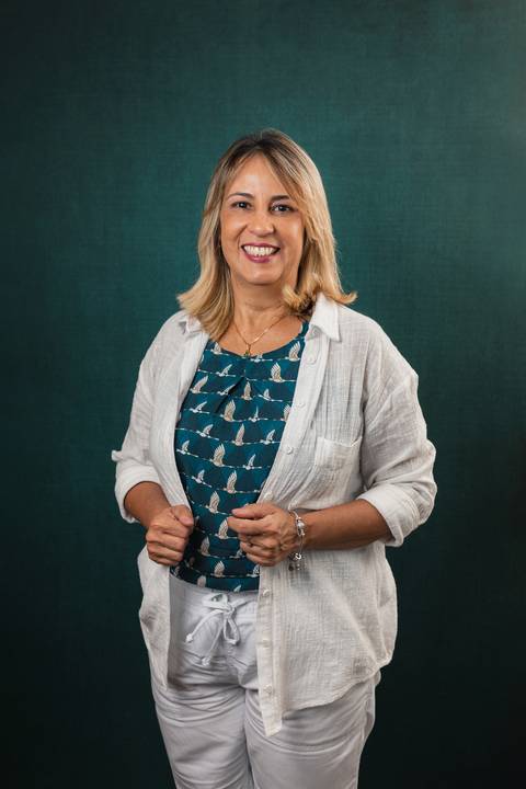 Psicóloga clínica em ensaio com fundo fotográfico verde'