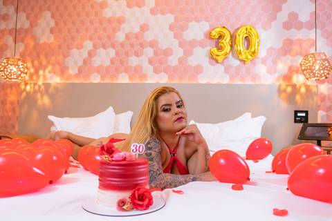 foto-sensual-mulher-de-lingerie-na-cama-com-bolas-de-aniversario-e-bolo'