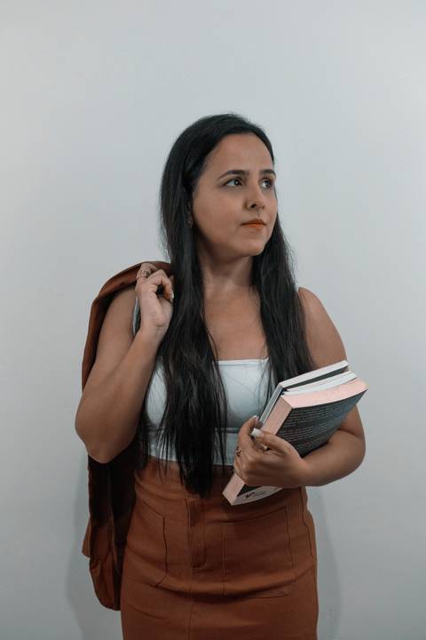 foto-corporativa-de-contadora-com-roupa-social-com-livros'