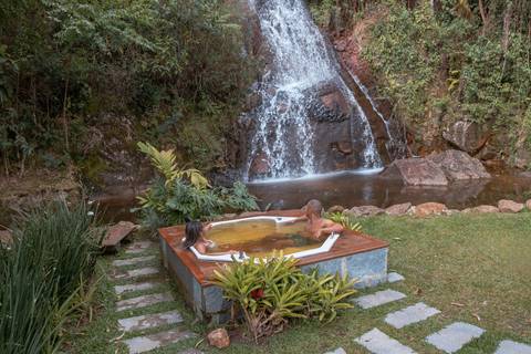 Casal na pousada BlueBear Cabins na hidromassagem'