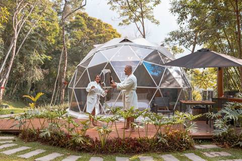 Casal na pousada BlueBear Cabins estourando espumante'