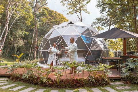 Casal na pousada BlueBear Cabins estourando espumante'
