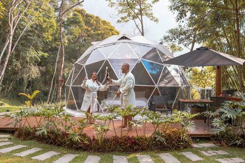 Casal na pousada BlueBear Cabins estourando espumante'