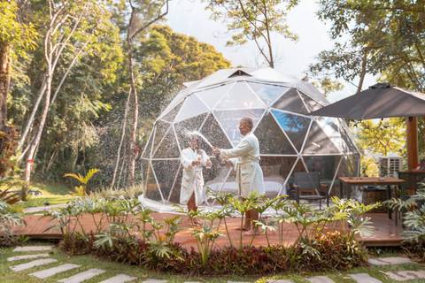 Casal na pousada BlueBear Cabins estourando espumante'