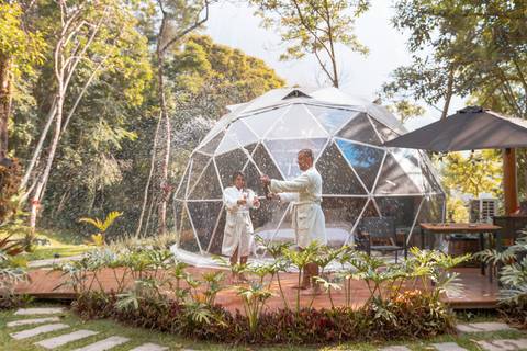 Casal na pousada BlueBear Cabins estourando espumante'