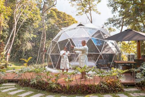 Casal na pousada BlueBear Cabins estourando espumante'