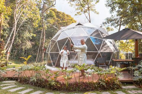 Casal na pousada BlueBear Cabins estourando espumante'