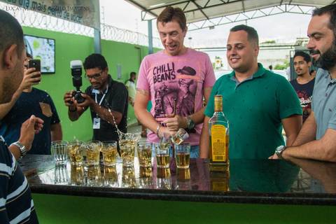 copos de tequila caindo dentro de copos de cerveja, amigos do noivo olhando'