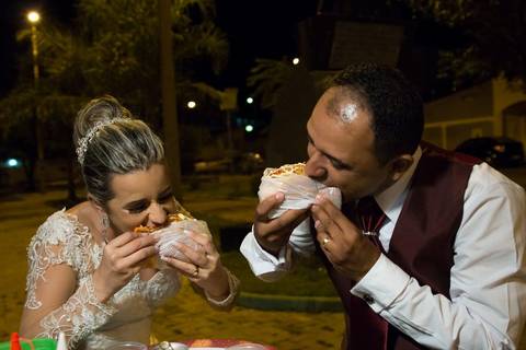 Fotografia dos noivos comendo cachorro quente em ensaio pós casamento feito na cidade de Araçuaí - MG'