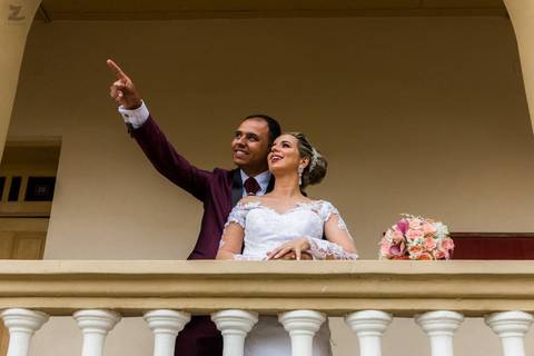 Fotografia do noivo apontando para o horizonte e a noiva olhando na direção'