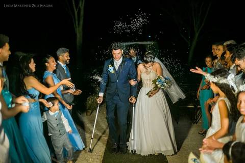 fotografia da chuva de arroz durante a saída dos noivos, o noivo usava muletas, em casamento realizado em Coronel Murta.'