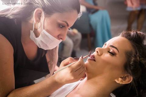 fotografia de maquiagem da noiva. Maquiadora de máscara, aplicando batom na boca da noiva'