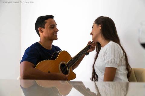 fotografia do marido tocando violão para a esposa durante ensaio fotográfico pós casamento em Virgem da Lapa - MG'