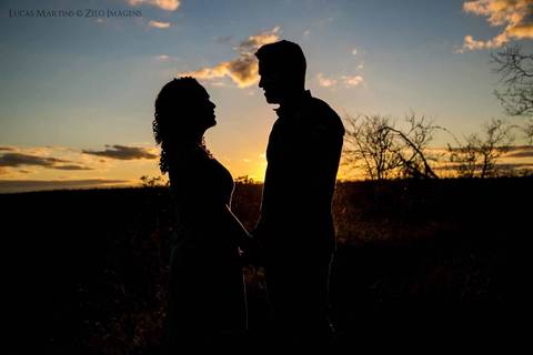 fotografia em silhueta do casal, durante por do sol em ensaio fotográfico de casal em Araçuaí, Minas Gerais.'