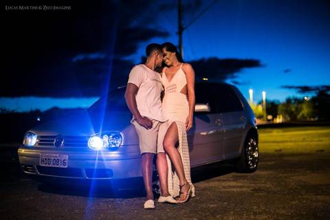 Casal posando para fotografia a noite, após por do sol, apoiados em carro Golf com faróis de Led. Em ensaio fotográfico de casal realizado na cidade de  Araçuaí, Minas Gerais'