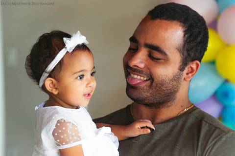pai brincando mostrando a lingua para filha'