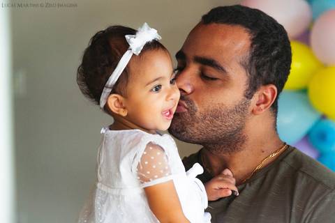 pai beijando a filha no colo'