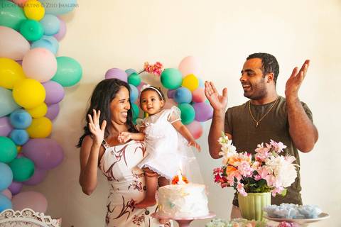 pai, mãe e filha cantando parabens'