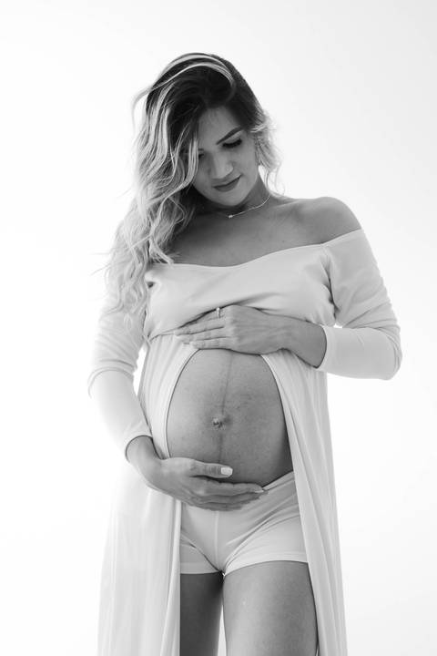 ensaio gestante usando vestido longo aparecendo a barriga'