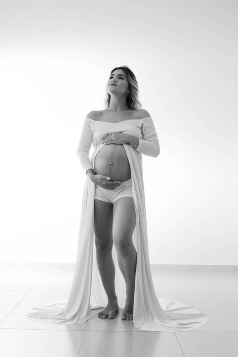 ensaio gestante usando vestido longo aparecendo a barriga'