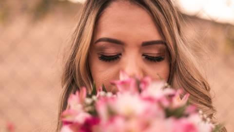 Noiva segurando seu buquê de flores cor de rosa.'