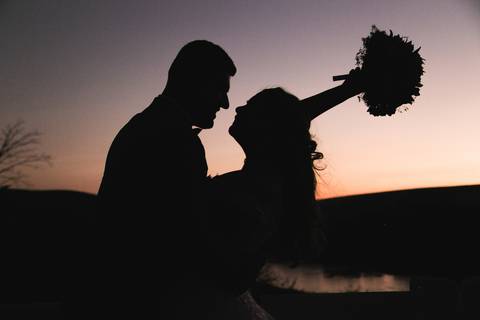 Silhueta de casal posando ao por do sol'