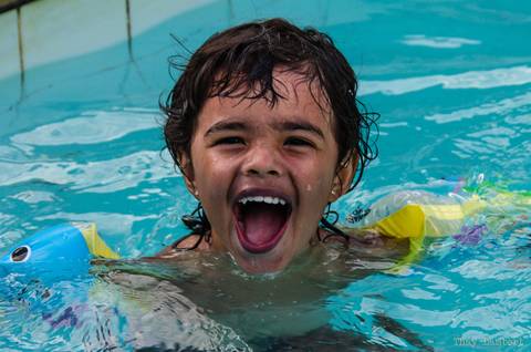 Criança sorrindo na piscina, fotografia de aniversário infantil'