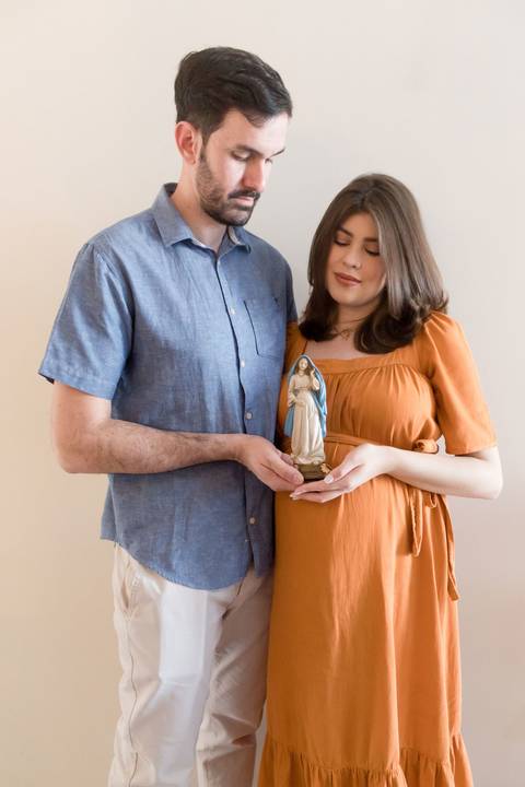 Ensaio fotográfico de gestante em casa; família católica; gestação; maternidade'