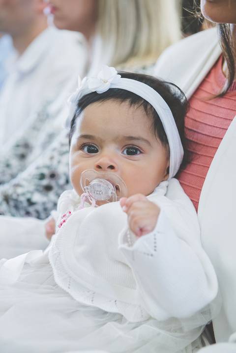 Beatriz com laço na cabeça em dia de batizado na igreja  do Fátima'