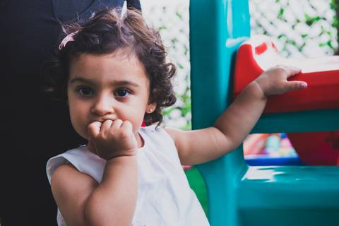 Mão na boca com olhar curioso para foto'