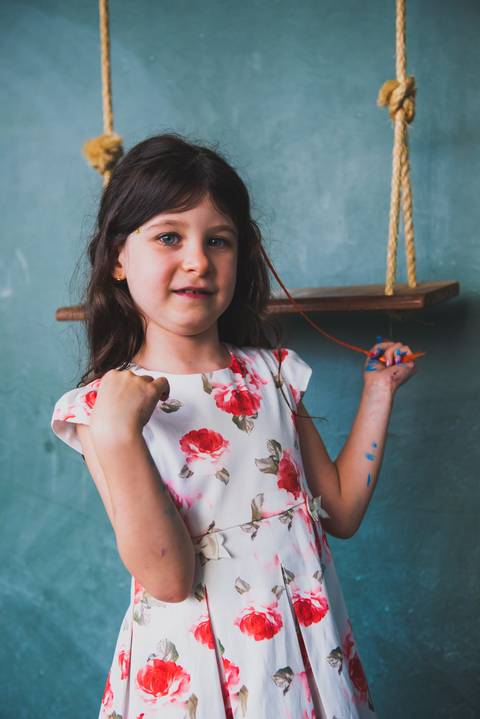 Vestida de vestido de flores vermelhas resaltam o rosto da criança'