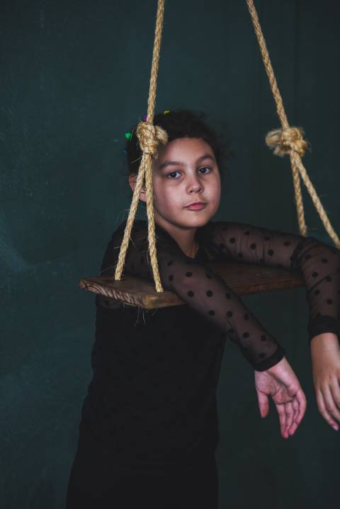 Menina posa para retrato em balanço'
