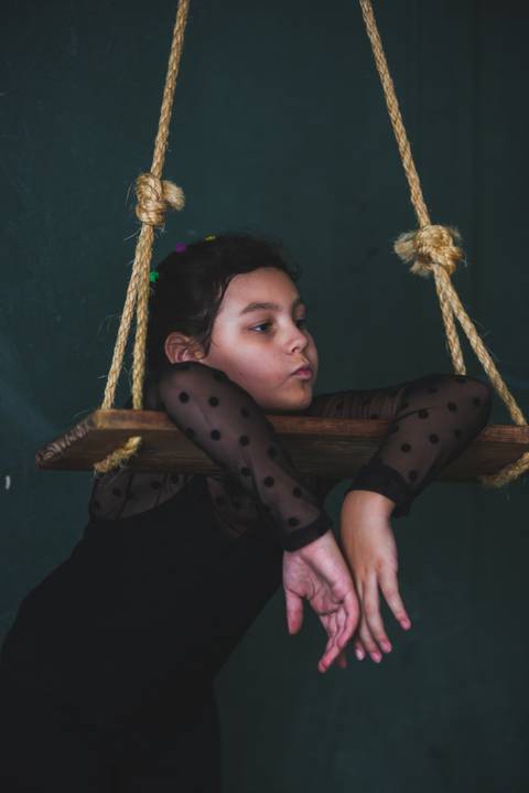 Se descontraindo no balanço , menina se sente tranquila'