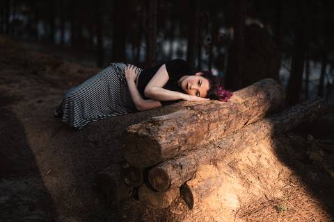Modelo deita sob o tronco em ensaio fotografico em sanja'