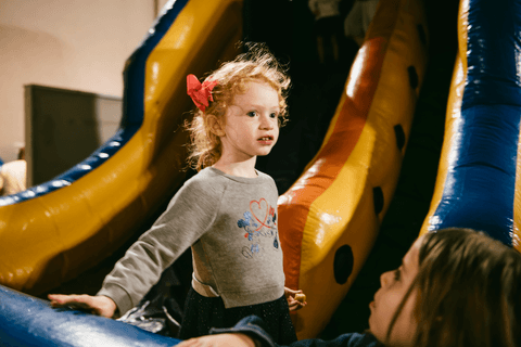 Meninas se divertem no escorregador inflável'